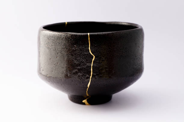 istock Antique broken Japanese raku black bowl repaired with gold kintsugi technique 1280370397