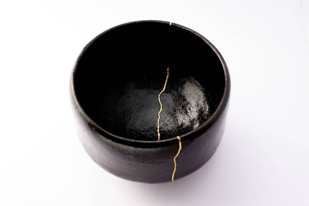 istock Antique broken Japanese raku black bowl repaired with gold kintsugi technique 1280370420