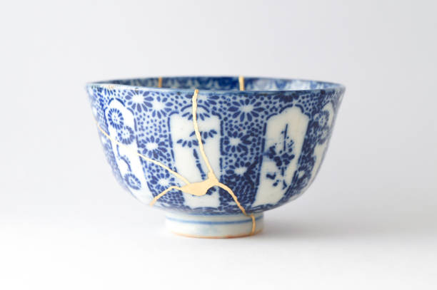 Antique broken Japanese bowl repaired with gold kintsugi technique stock photo