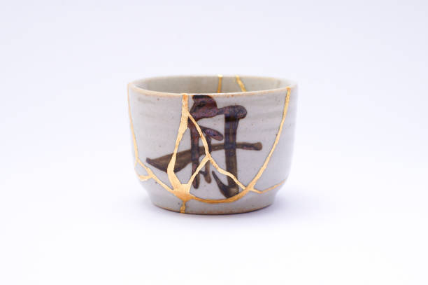 istock Antique broken Japanese beige sake cup repaired with gold kintsugi technique 1280370576