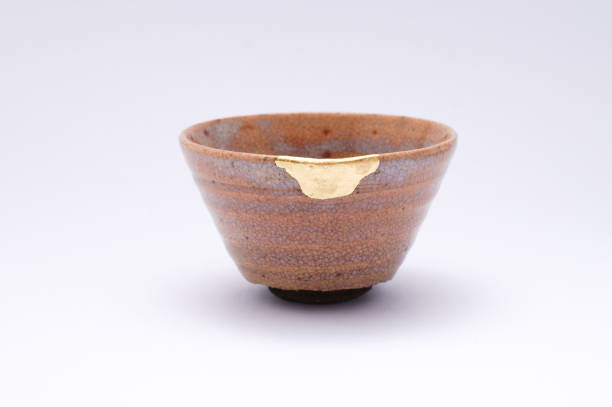 istock Antique broken Japanese beige sake cup repaired with gold kintsugi technique 1280370631