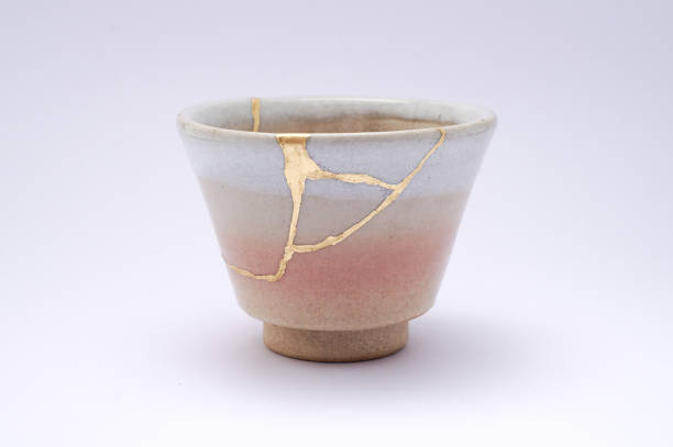istock Antique broken Japanese beige sake cup repaired with gold kintsugi technique 1280370637
