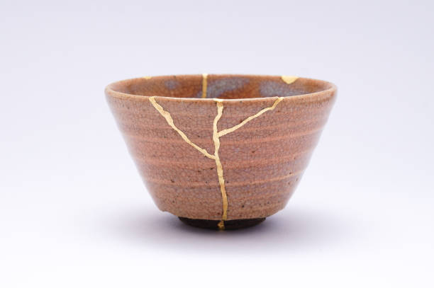 istock Antique broken Japanese beige sake cup repaired with gold kintsugi technique 1280370653