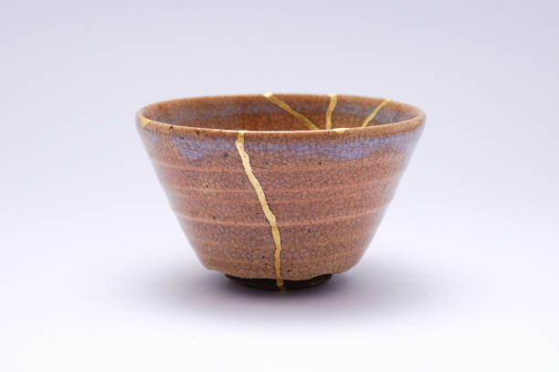 istock Antique broken Japanese beige sake cup repaired with gold kintsugi technique 1280370660