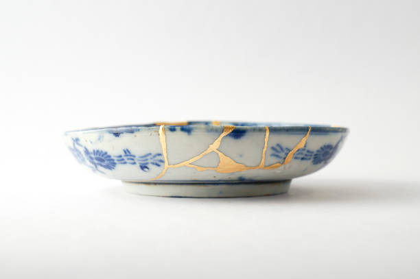 Antique broken Japanese plate repaired with gold kintsugi technique stock photo