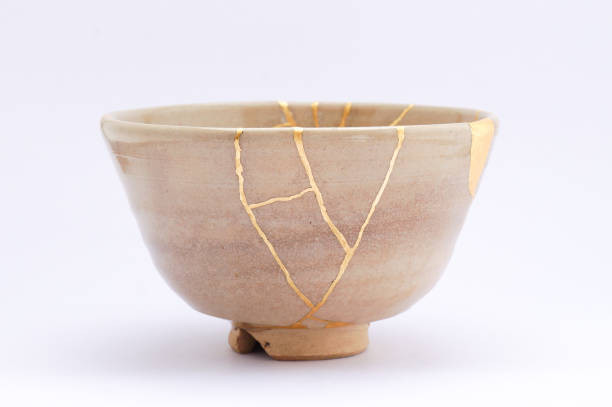 istock Antique broken Japanese beige bowl repaired with gold kintsugi technique 1280370734