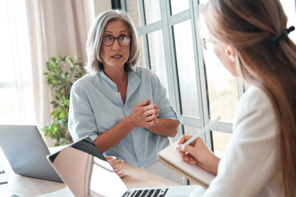 istock Mature old female mentor or manager training young intern explaining sharing professional skills in office. Middle aged senior business woman teacher speaking to student teaching trainee at meeting. 1280371013