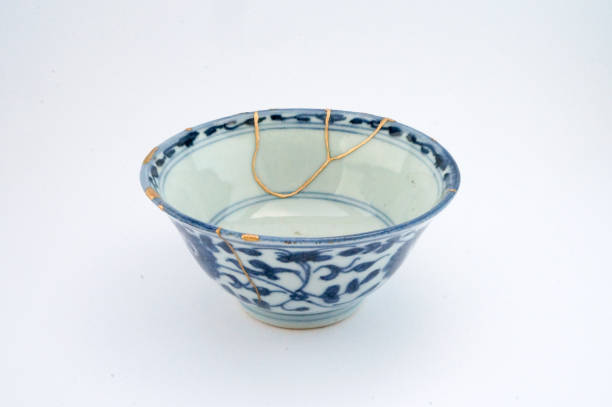 Antique broken Japanese bowl repaired with gold kintsugi technique stock photo