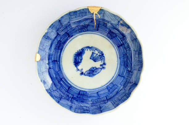 Antique broken Japanese plate repaired with gold kintsugi technique stock photo