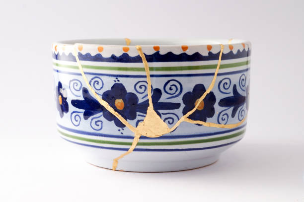 Antique broken Italian bowl repaired with gold kintsugi technique stock photo