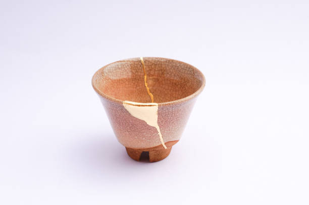 istock Antique broken Japanese beige cup repaired with gold kintsugi technique 1280373178