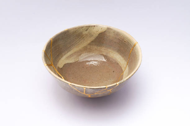 istock Antique broken Japanese beige bowl repaired with gold kintsugi technique 1280373202