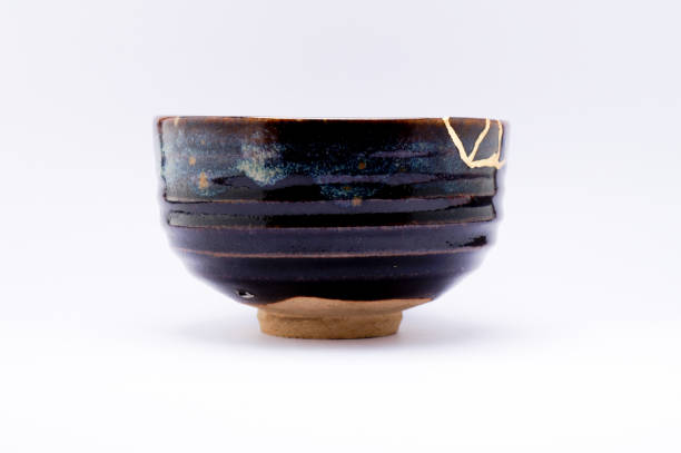 istock Antique broken Japanese black raku bowl repaired with gold kintsugi technique 1280373242