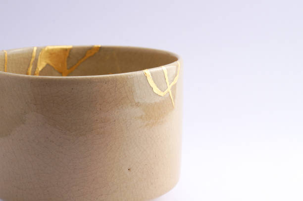 istock Antique broken Japanese beige bowl repaired with gold kintsugi technique 1280373266