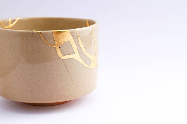 Antique broken Japanese beige bowl repaired with gold kintsugi technique