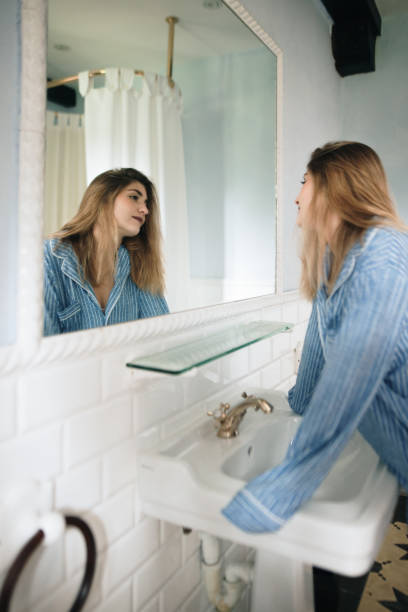 istock Young blonde woman looking in the mirror 1280373342