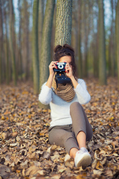 istock Woman photographing autumn forest 1280376052