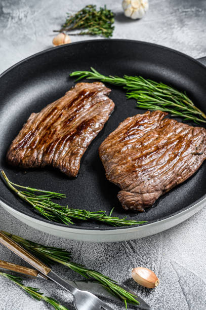 istock Roasted flat iron and flank steaks. Marble beef meat. Gray background. Top view 1280376253