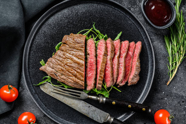 istock Grilled and cut Flat Iron steak. Marble beef meat. Black background. Top view 1280376713