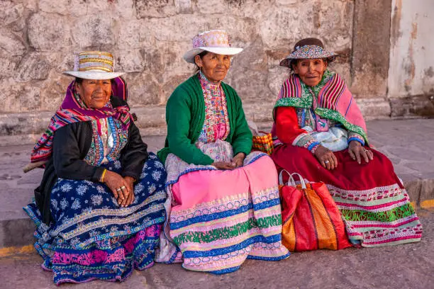 Peruvian women wearing national clothing waiting for a bus. Chivay is a town in the Colca valley, capital of the Caylloma province in the Arequipa region, Peru. Located at about 12,000 ft above sea level, it lies upstream of the renowned Colca Canyon. It has a central town square and an active market. Ten kilometers to the east, and 1,500 meters above the town of Chivay lies the Chivay obsidian source. Thermal springs are located 3 km from town, a number of heated pools have been constructed. A stone "Inca" bridge crosses the Colca River ravine, just to the north of the town. The town is a popular staging point for tourists visiting Condor Cross or Cruz Del Condor, where condors can be seen catching thermal uplifts a few kilometers downstream.