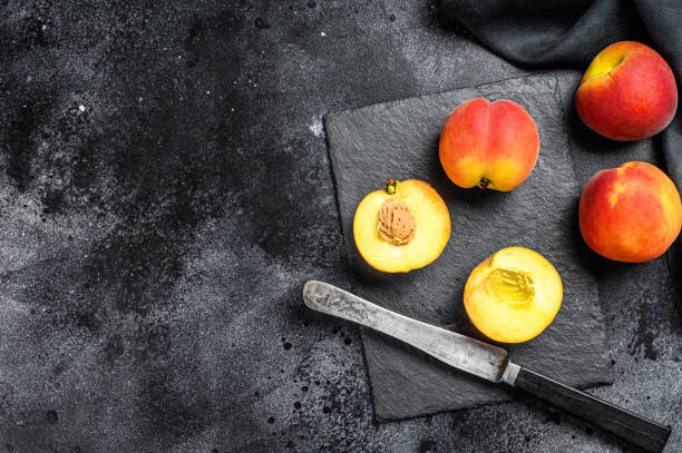 istock Organic Peaches fruit on a black stone Board. Black background. Top view. Copy space 1280380056