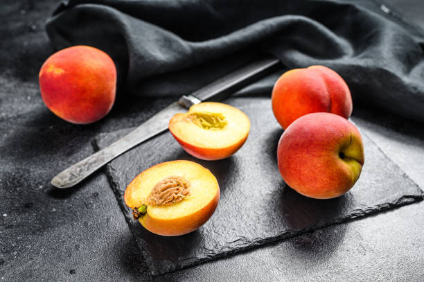 istock Organic Peaches fruit on a black stone Board. Black background. Top view 1280380095