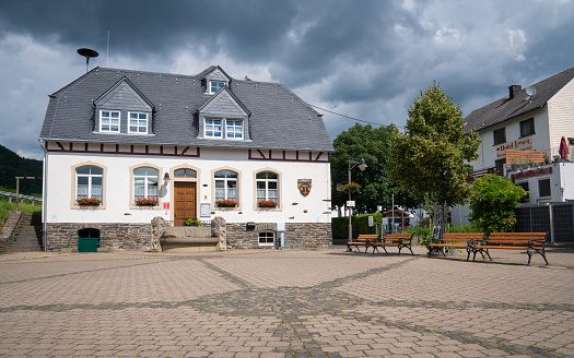 Enkirch, Germany - June 20, 2020: Panoramic image of the tourist information office of the Moselle village Enkirch against dramatic sky on June 20, 2020 in Germany