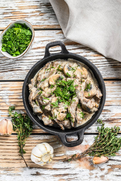 istock Beef Stroganoff with mushrooms and fresh parsley. White background. Top view 1280381270