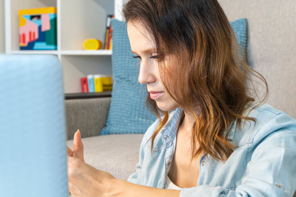 istock Serious woman using mobile phone while working at home with laptop. 1280382506