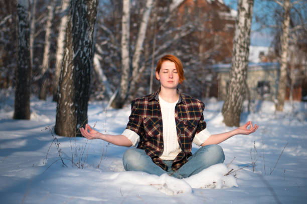 istock Young woman in lotus pose on snowy forest. 1280382727