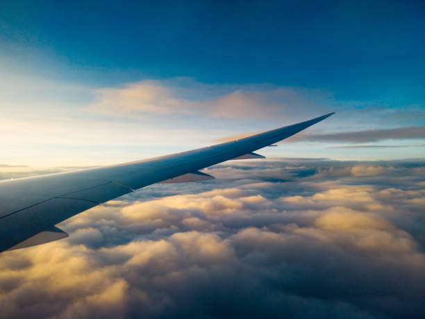 istock Dreamy clouds at sunset seen through the airplane window 1280382826