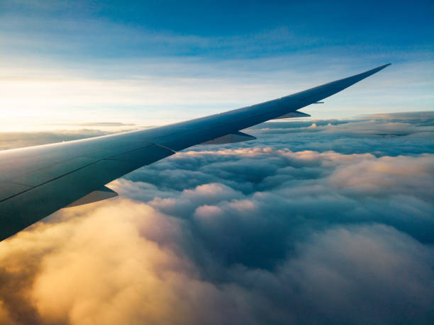 istock Dreamy clouds at sunset seen through the airplane window 1280382831