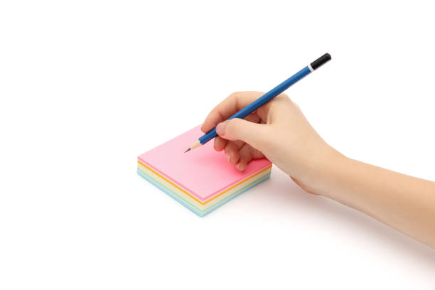 istock Pencil in woman's hand and sticker or sticky post-it notes on a white background. 1280384422