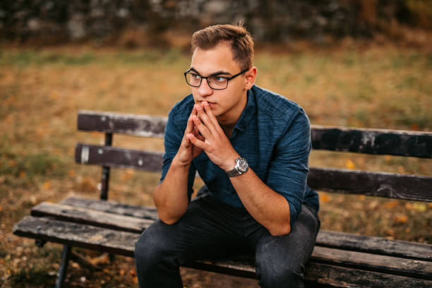 Nervous man sitting on bench in park