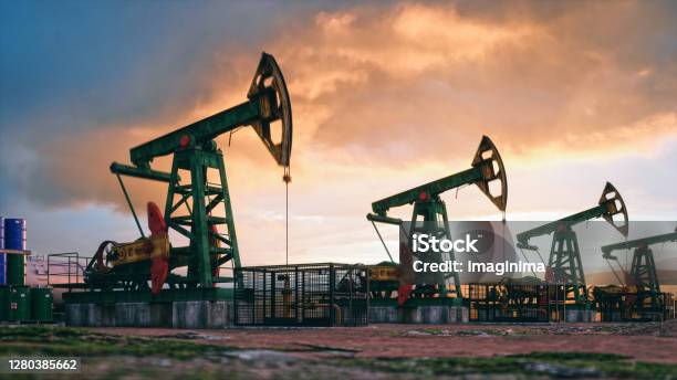 Working Pumpjacks On Sunset Stock Photo - Download Image Now - Crude Oil, Gasoline, Drilling Rig
