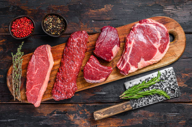 Raw prime black angus beef steaks fillet Mignon, rib eye or cowboy, Striploin or new york, skirt or machete. Wooden dark background. Top view Raw prime black angus beef steaks fillet Mignon, rib eye or cowboy, Striploin or new york, skirt or machete. Wooden dark background. Top view. Machete stock pictures, royalty-free photos & images