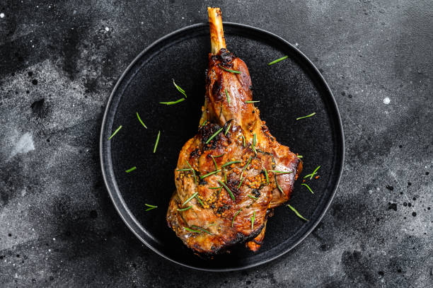istock Oven baked lamb leg.  Dark background. Top view 1280386986