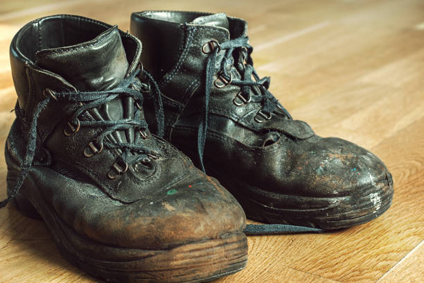 istock Old worn-out workman's shoes. Shoes that require repair or replacement 1280389555
