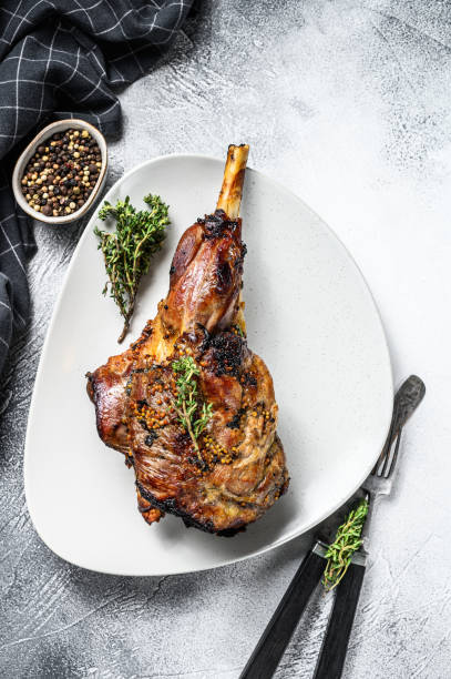 BBQ lamb leg with herbs. Gray background. Top view
