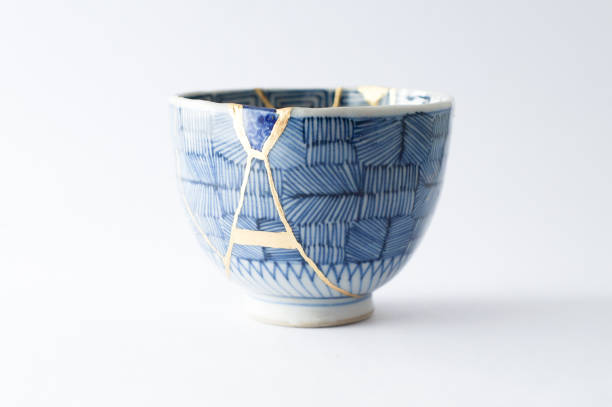 Antique broken Japanese blue bowl repaired with gold kintsugi technique stock photo