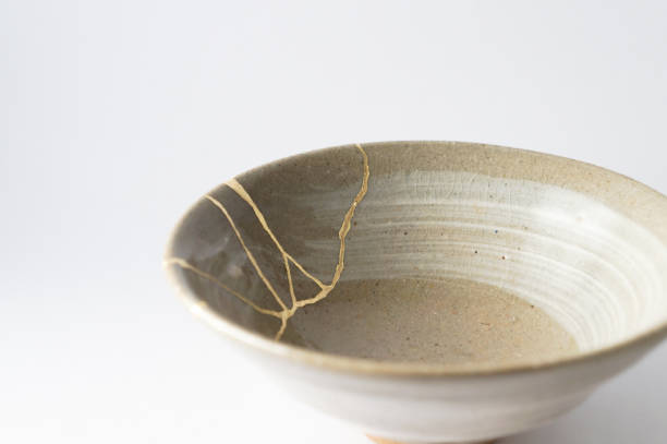 Antique broken Japanese tea matcha bowl repaired with gold kintsugi technique stock photo
