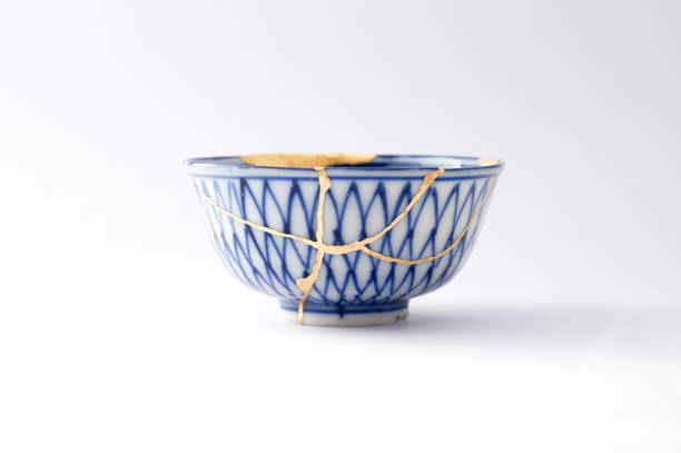 Antique broken Japanese blue bowl repaired with gold kintsugi technique stock photo