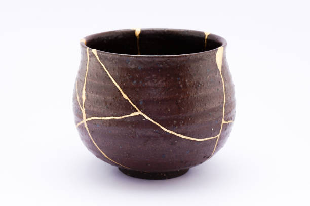 Antique broken Japanese black bowl repaired with gold kintsugi technique
