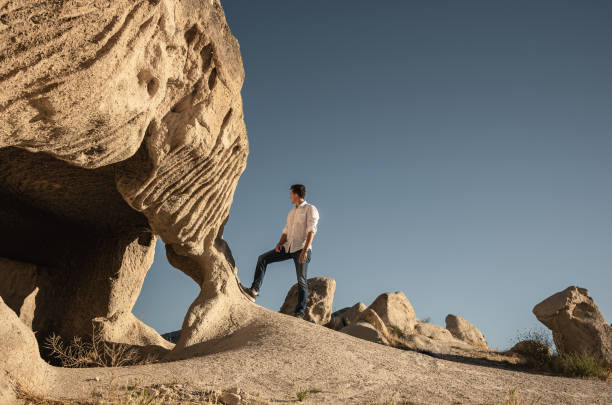 istock Man standing by the rock in desert. 1280393675
