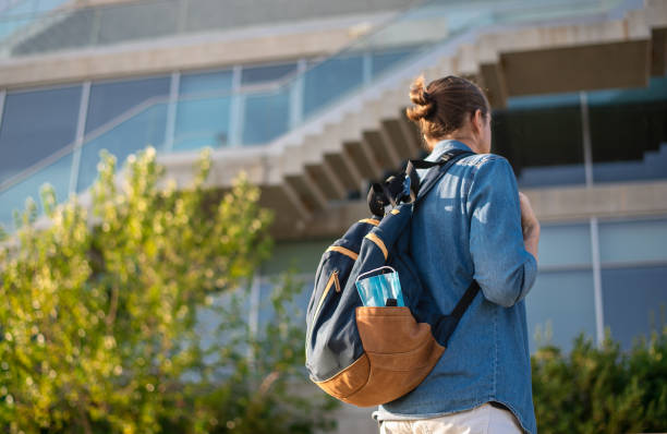 istock Back view of student with backpack and medical face mask. 1280395201