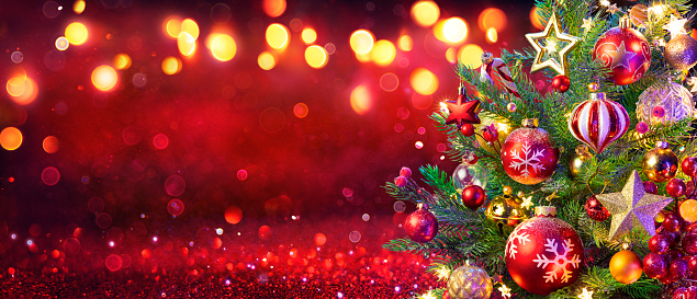 Seamless panoramic banner with Christmas composition of Christmas festive baubles and branches of fir tree on a beige background. Defocused lights on background. Copy space.