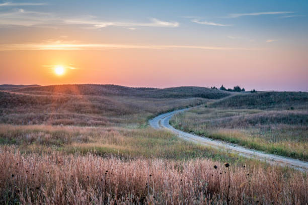 hazy sunrise over Nebraska Sandhills hazy sunrise over Nebraska Sandhills with a dirt sandy road  at Nebraska National Forest, fall scenery affected by wildfire smoke from Colorado and Wyoming nebraska stock pictures, royalty-free photos & images