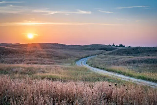 hazy sunrise over Nebraska Sandhills with a dirt sandy road  at Nebraska National Forest, fall scenery affected by wildfire smoke from Colorado and Wyoming