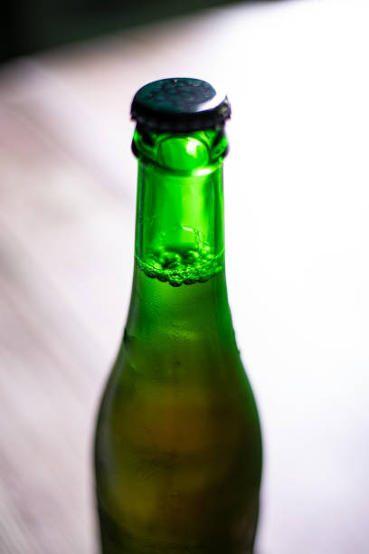 istock Blond beer on a green bottle closed on a wooden background 1280400444