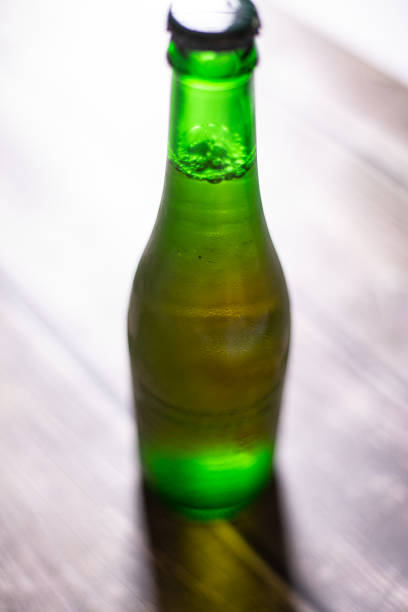 istock Blond beer on a green bottle closed on a wooden background 1280400499